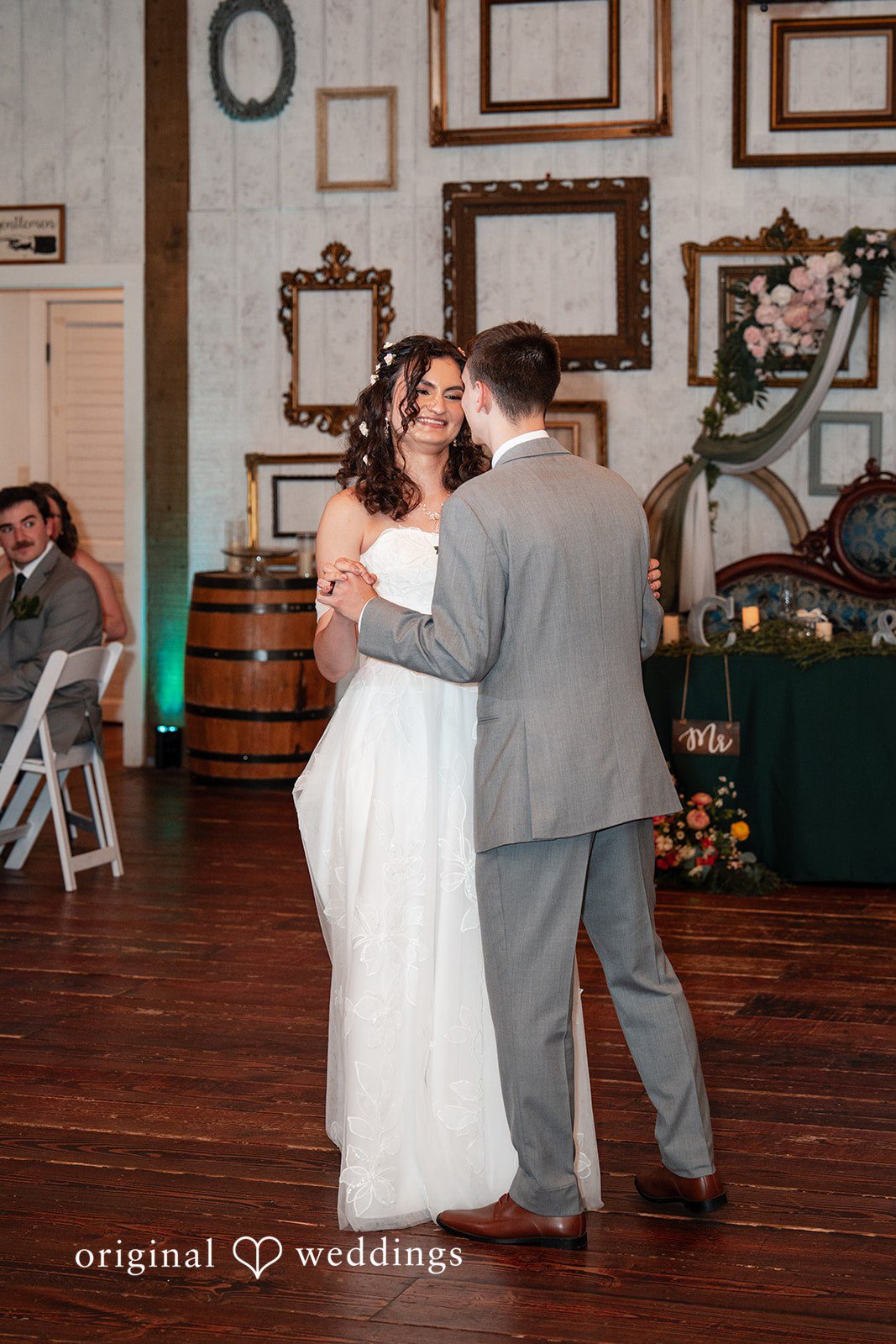 Conner + Ashley A bride and groom sharing a slow dance together on a wooden dance floor.