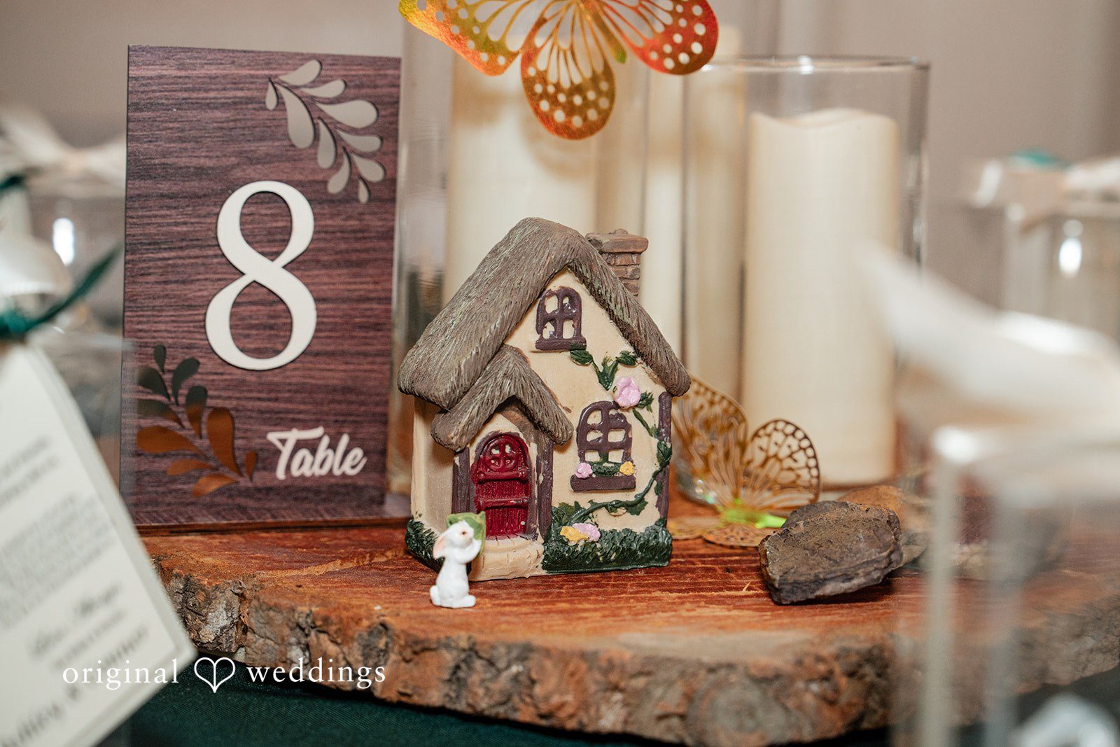 Conner + Ashley Table decor featuring a wooden block numbered eight, a small decorative lantern, and lit candles.
