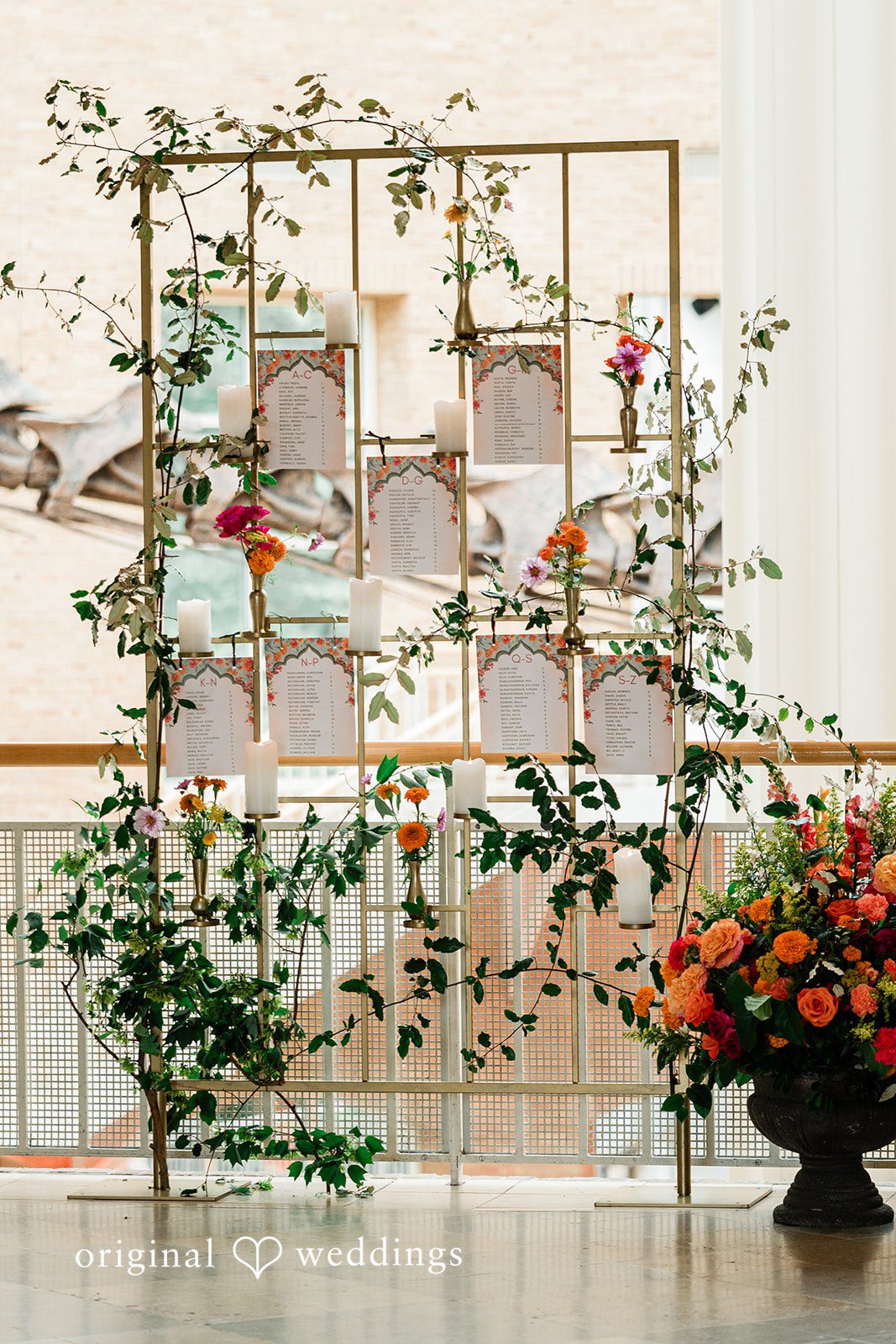 Sonya + Akshaya A decorative floral arch framing a grid-like wall structure.