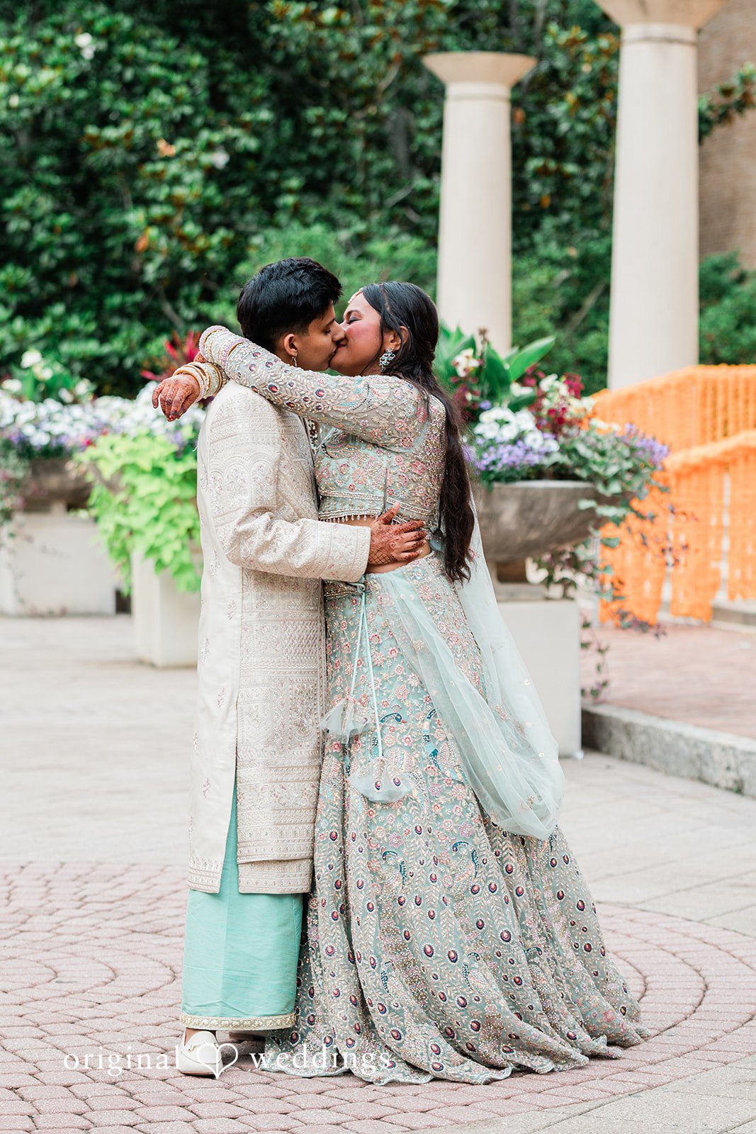 Sonya + Akshaya A couple embracing tightly in a full-length wedding portrait.