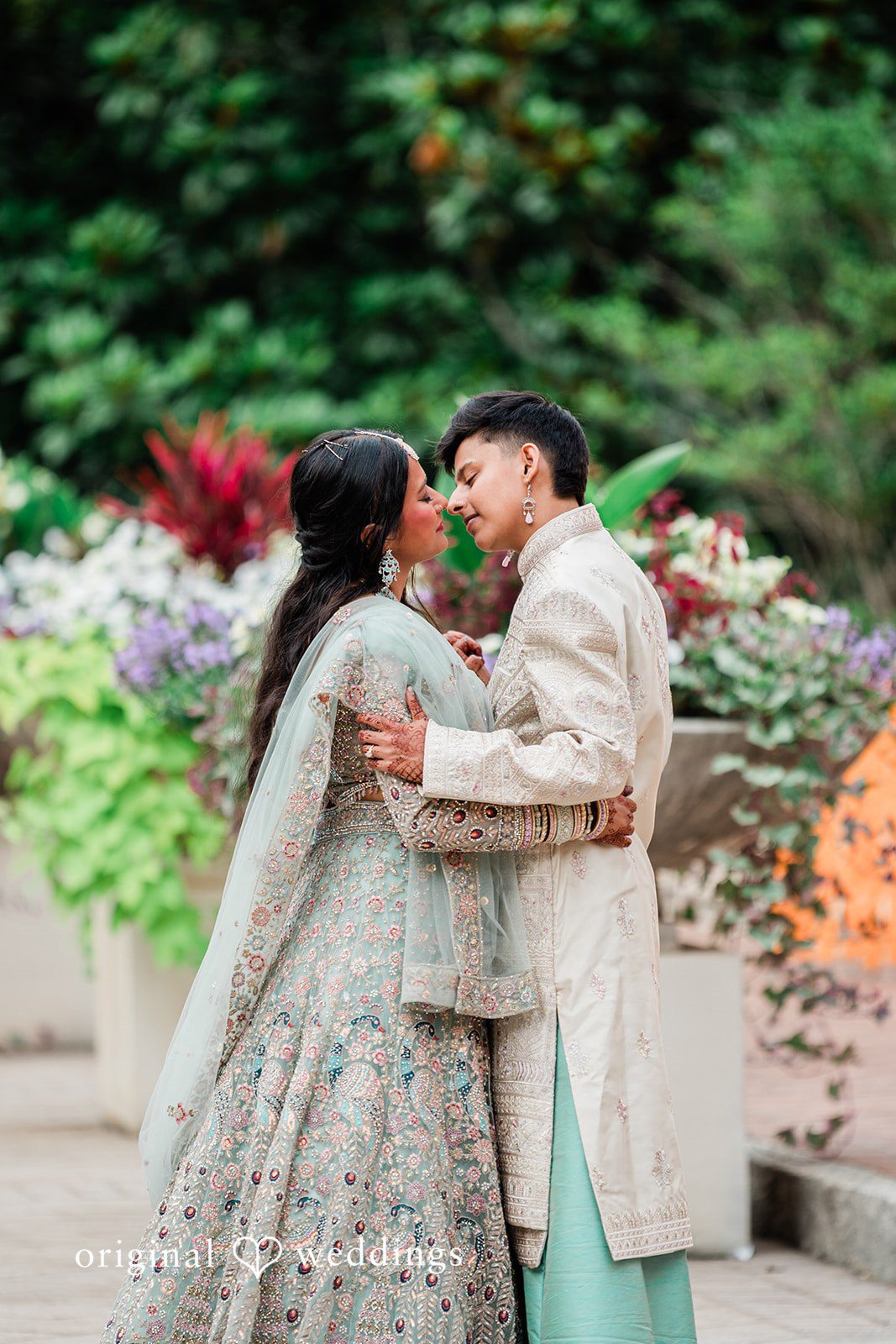 Sonya + Akshaya A bride and groom embracing while looking affectionately at each other.