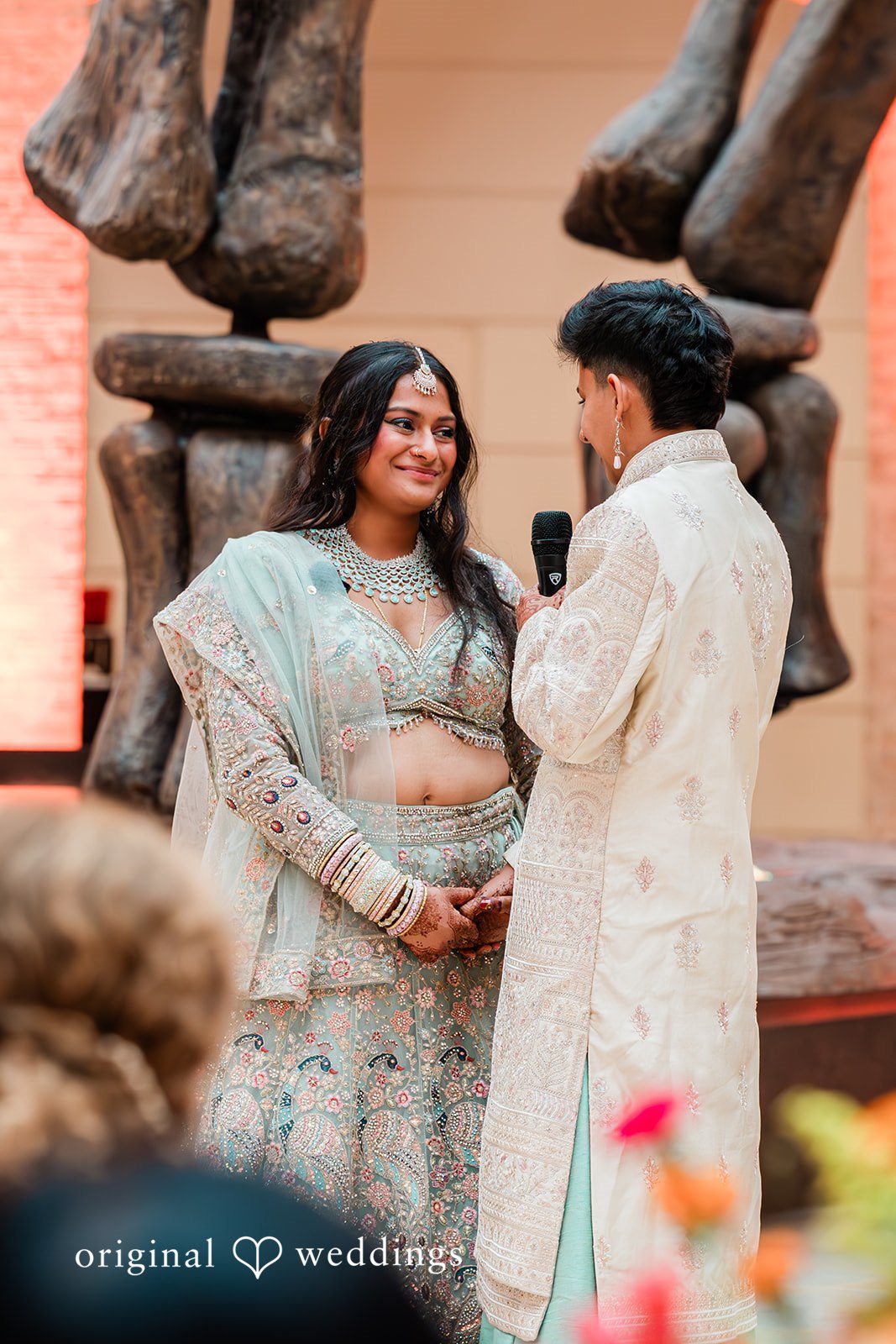 Sonya + Akshaya A couple sharing a happy conversation together in front of a stone structure.