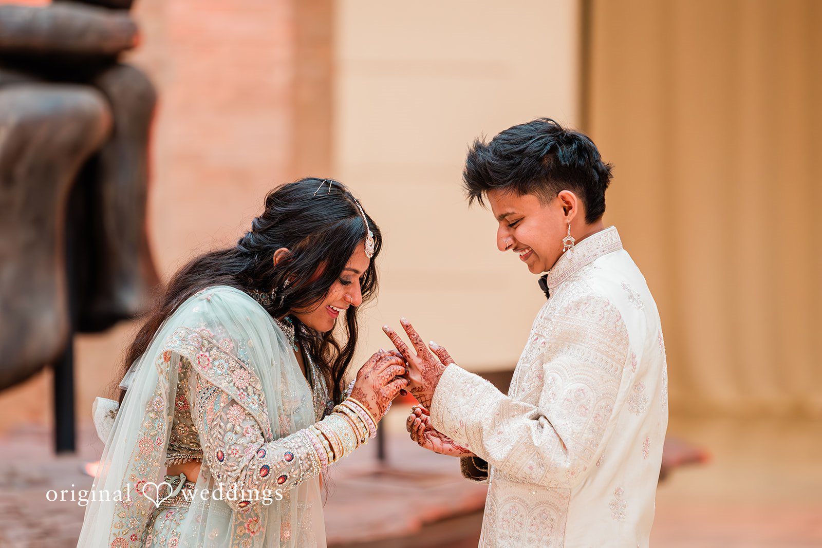 Sonya + Akshaya A couple holding hands and looking down during ceremony.