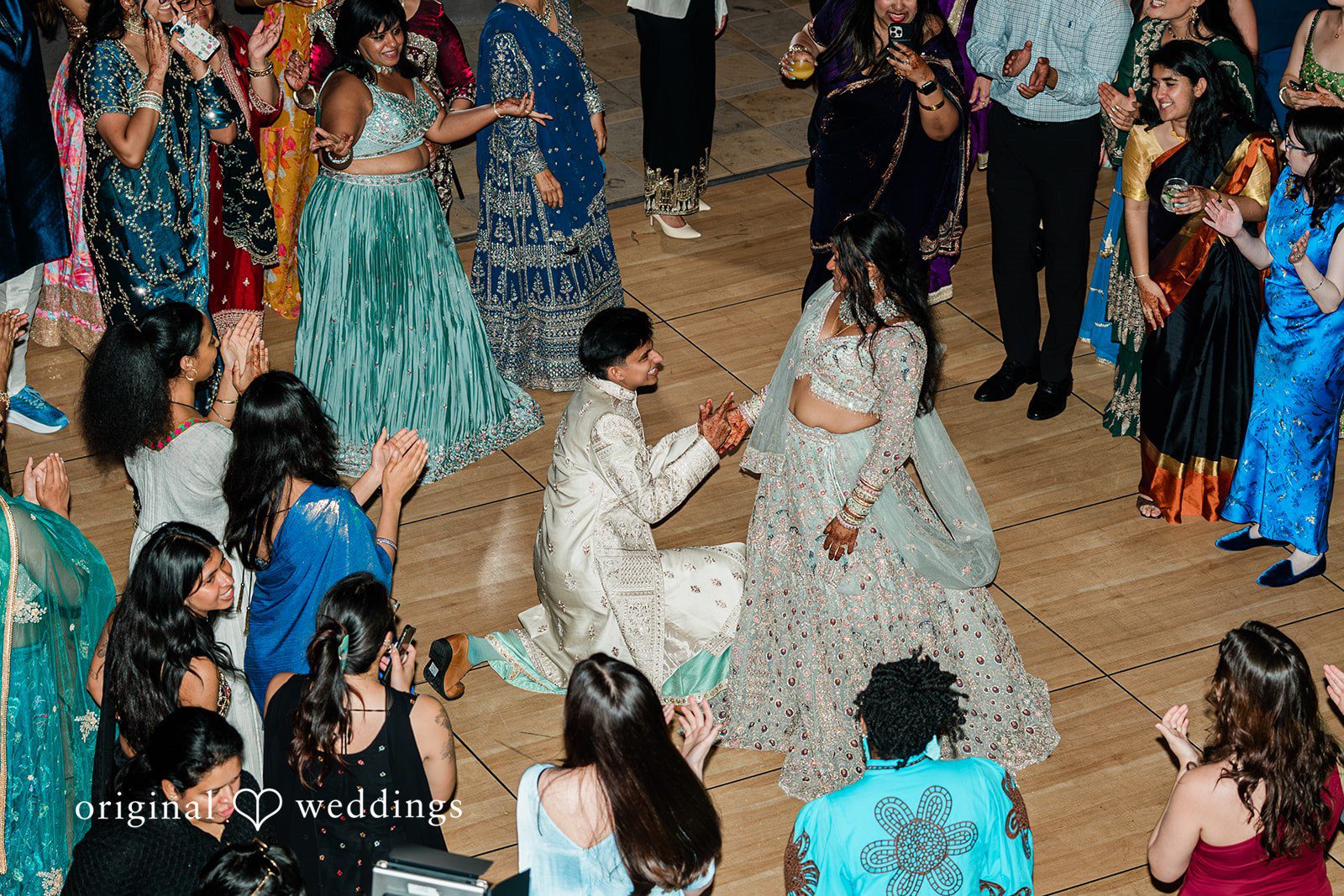 Sonya + Akshaya A high-angle view of a couple dancing in the center of a crowded dance floor.