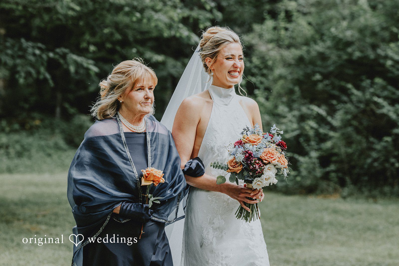 Bride standing next to an officiant holding a bouquet on a grassy field.