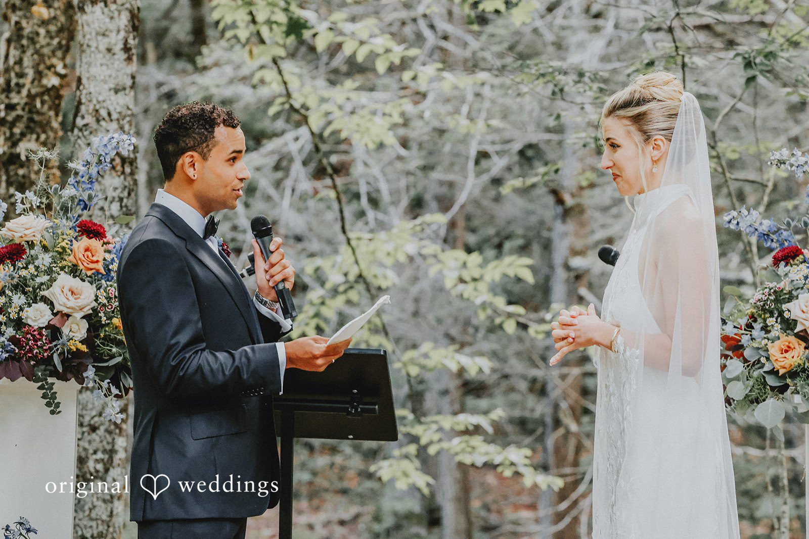 Groom looking at the bride during an altar ceremony with trees behind them.