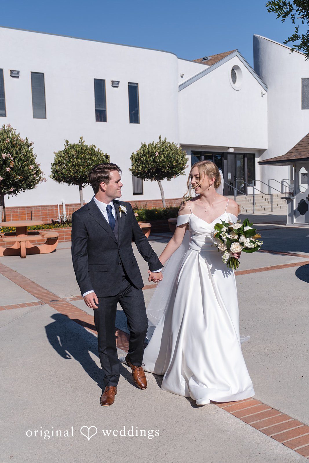 Madeline + Brady Bride and groom smiling while enjoying a peaceful walk together