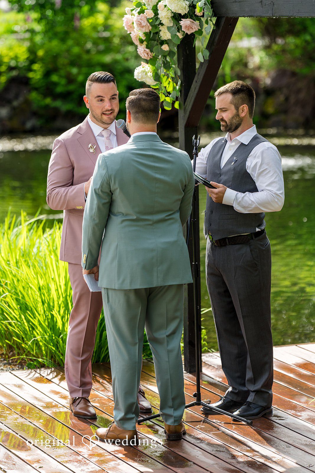 Kristian + Jeff Back view of couple standing before an officiant during their wedding ceremony.