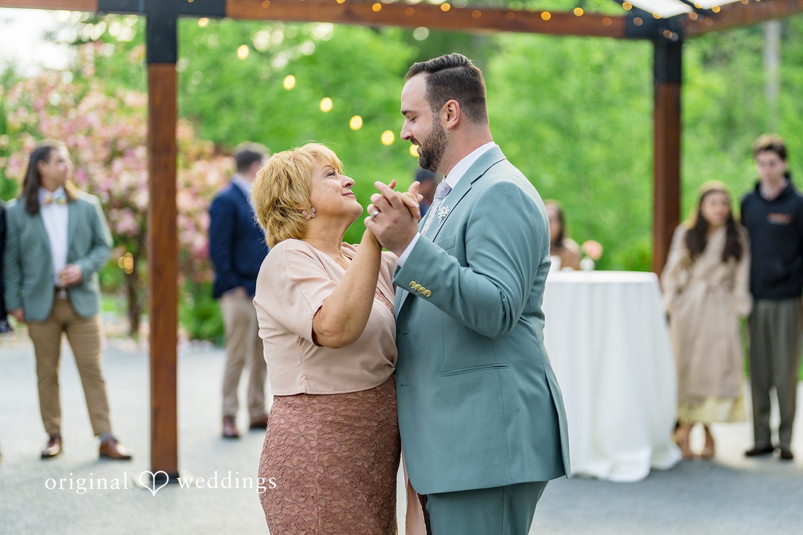 Kristian + Jeff A groom in a light blue suit dancing with an older woman during the wedding reception.