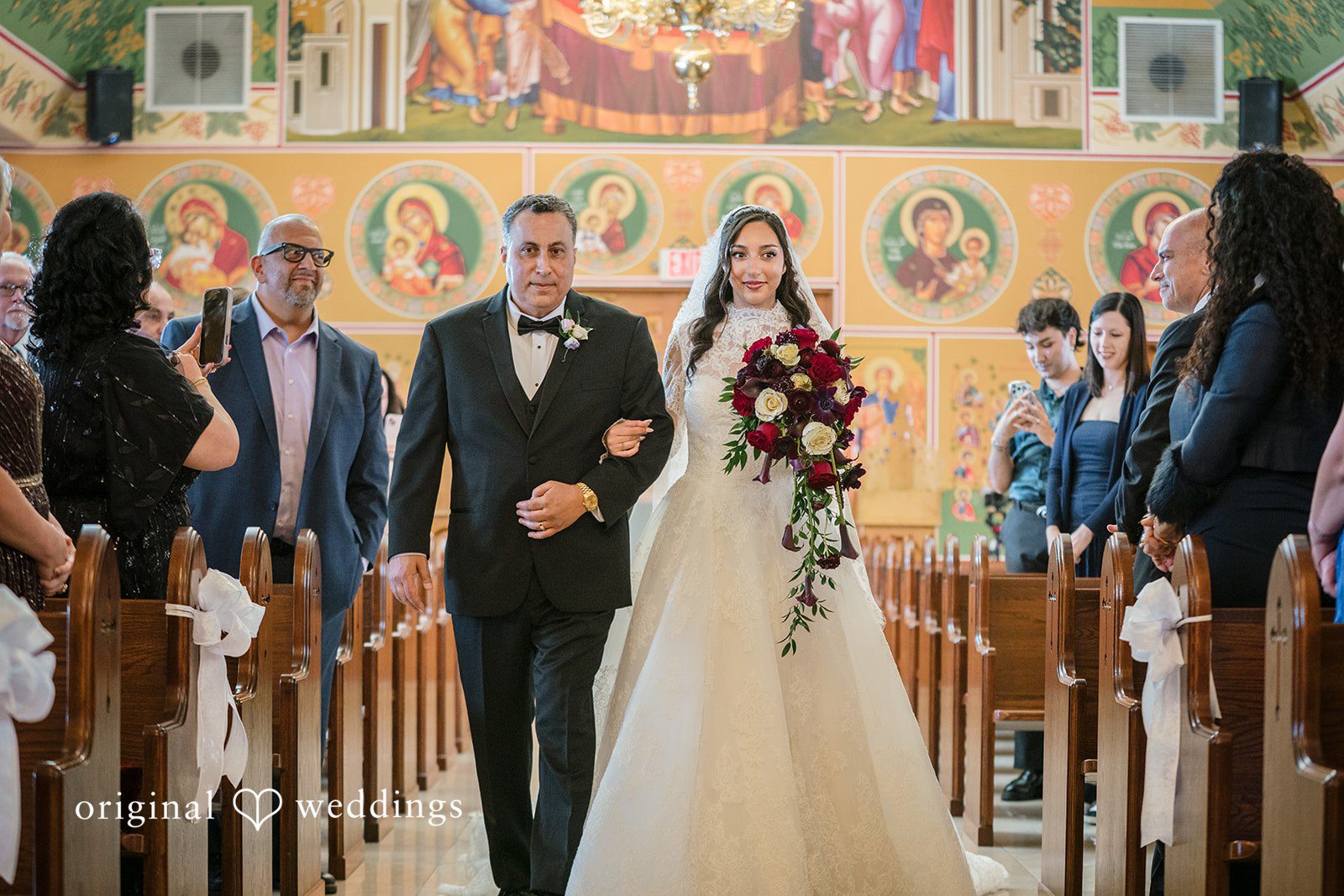 Janelle + Yaser Bride walking down the aisle with someone arms in arms