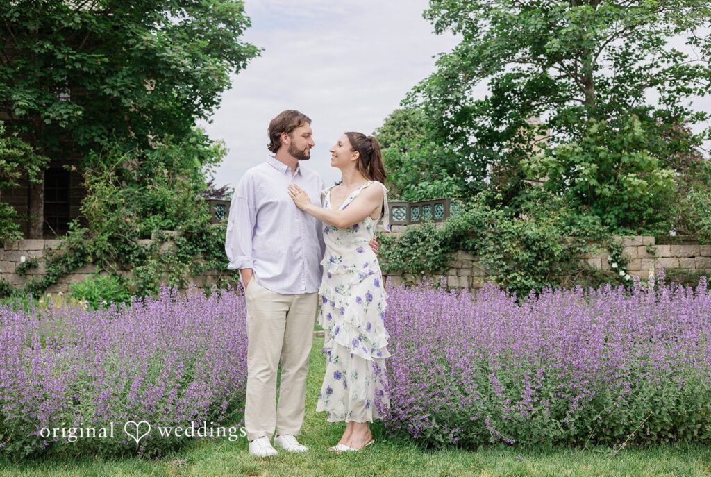 CT Engagement Photographers capturing couple standing while looking at each other and smiling at Harkness Park by Original Weddings