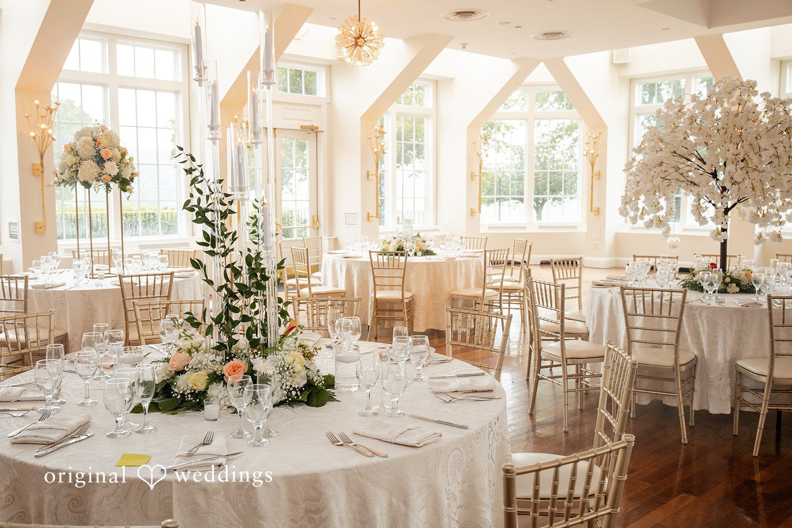 Elegant wedding reception table decorated with white floral arrangements.