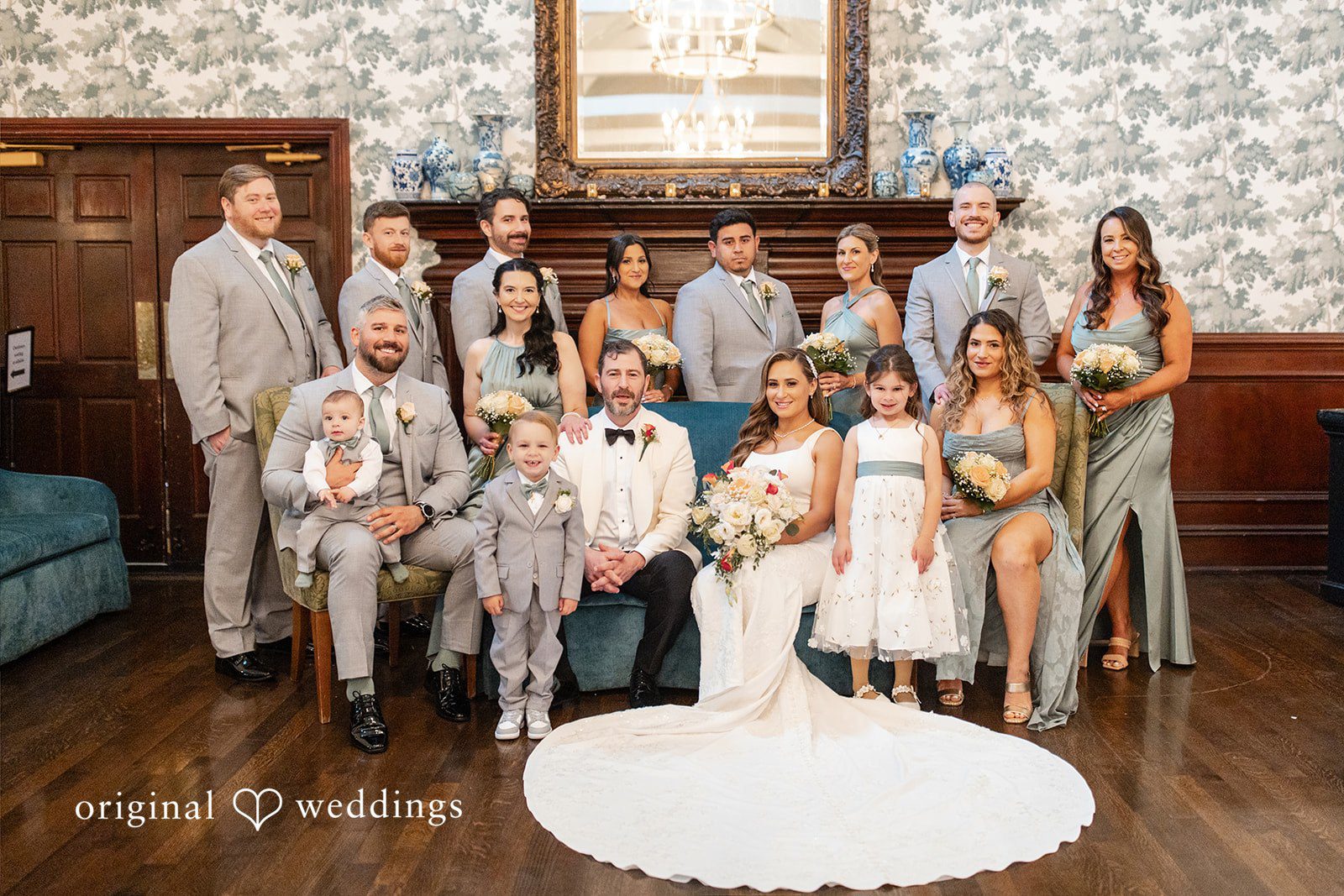 Full wedding party posing together in a beautifully decorated room.