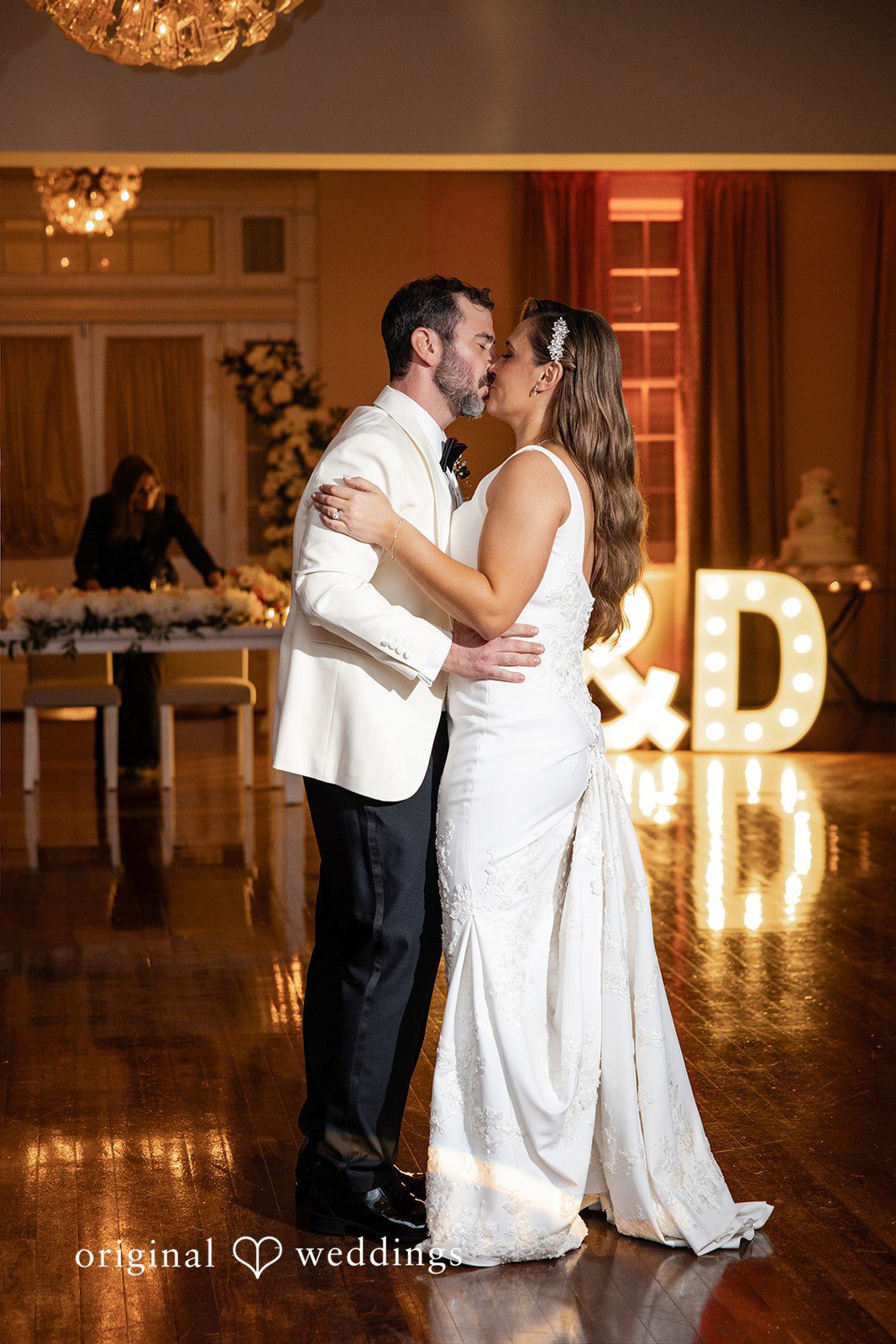 Bride and groom sharing their first dance under warm reception lighting.