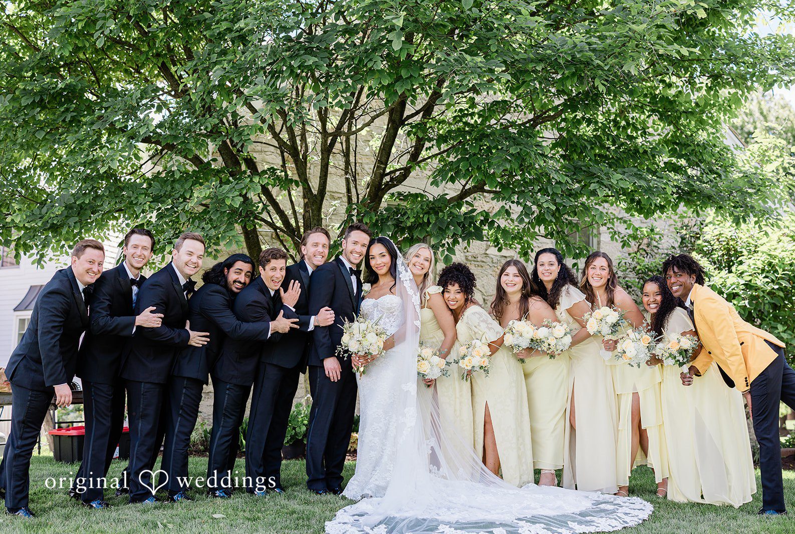 Chicago Wedding Photographers capturing couple with bridesmaids and groomsmen smiling at Chicago Backyard by Original Weddings