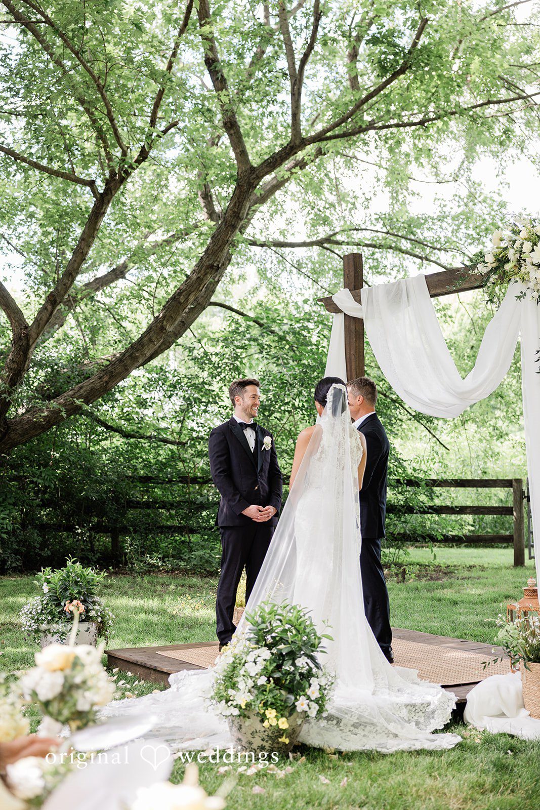 Bride and groom standing together with a  bride back view at Chicago Backyard