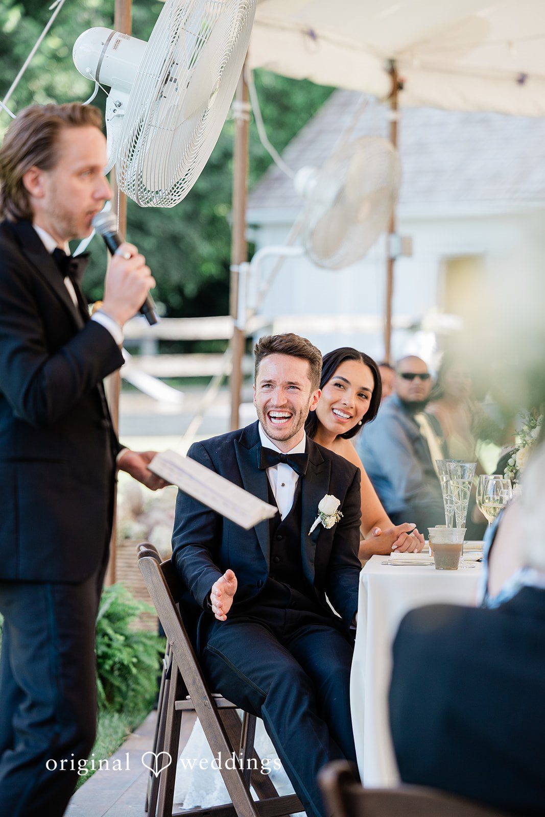 Couple smiling while sitting at the reception table at Chicago Backyard