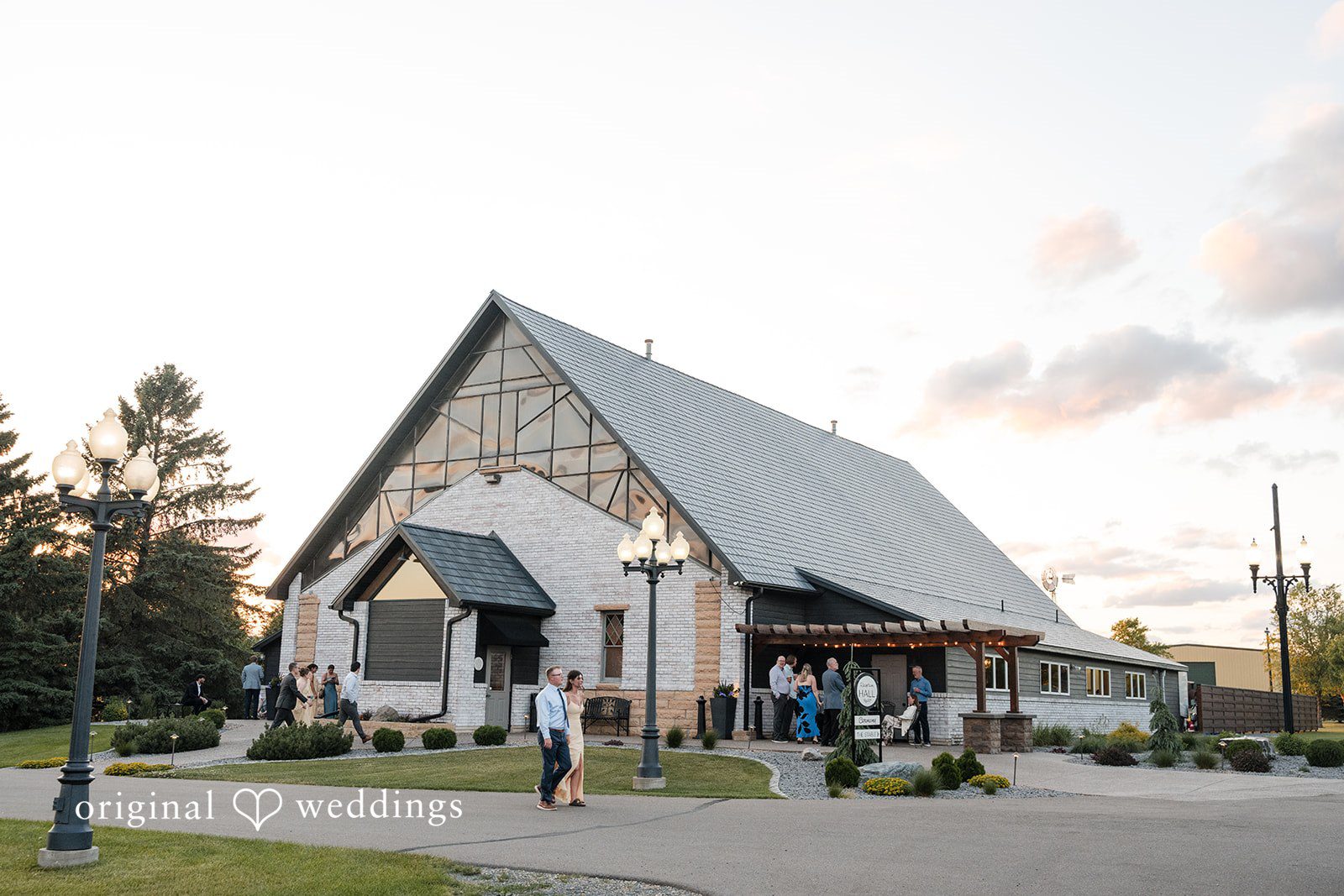 Cassandra + Adam Exterior view of a modern A-frame chapel venue during twilight.