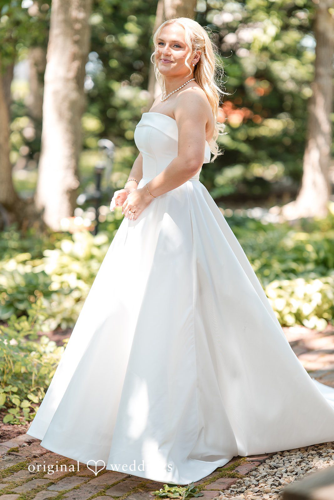 Cassandra + Adam Bride in a white ballgown dress posing and spinning in a wooded area.