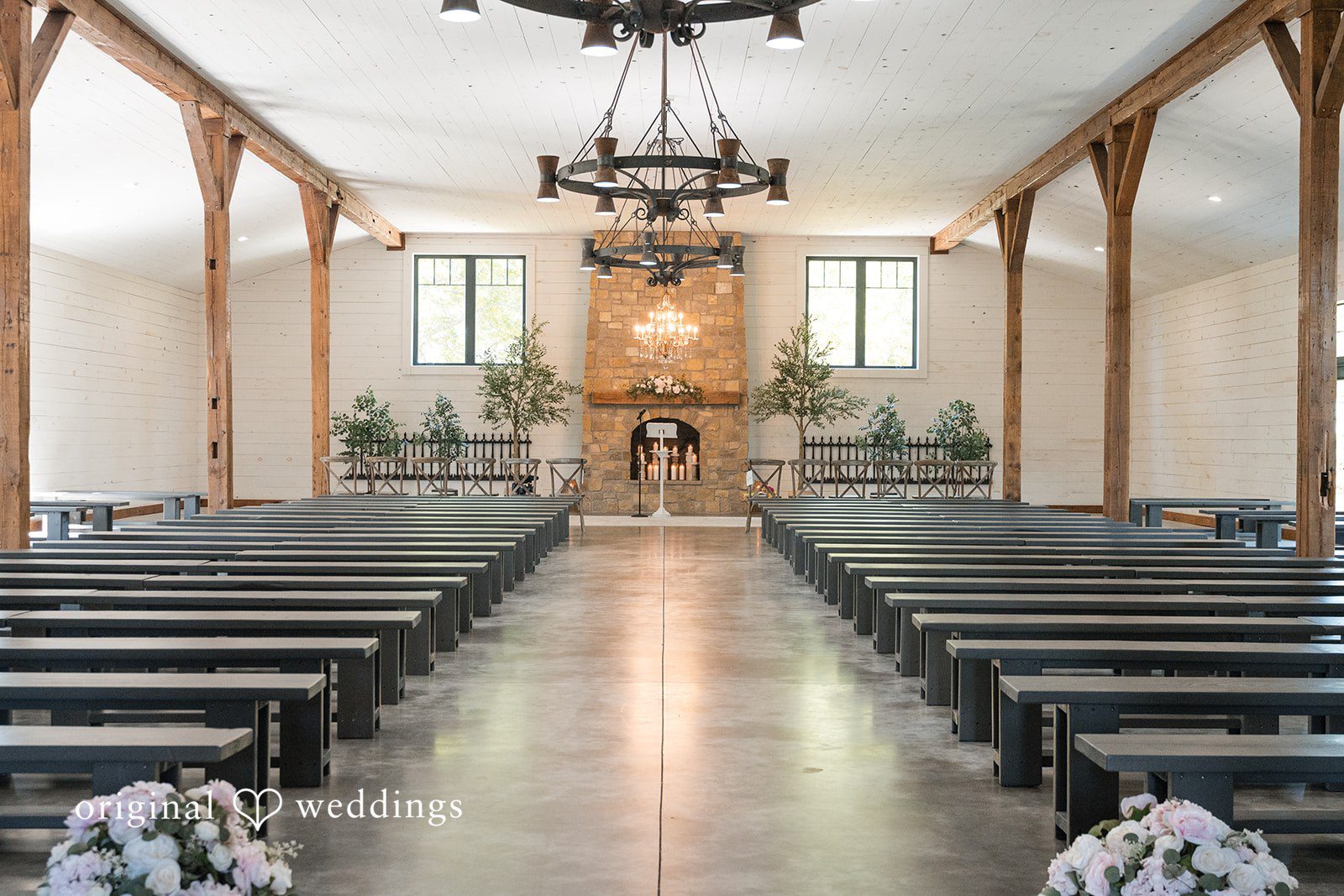 Cassandra + Adam Empty wedding chapel aisle with wooden pews leading toward the altar.