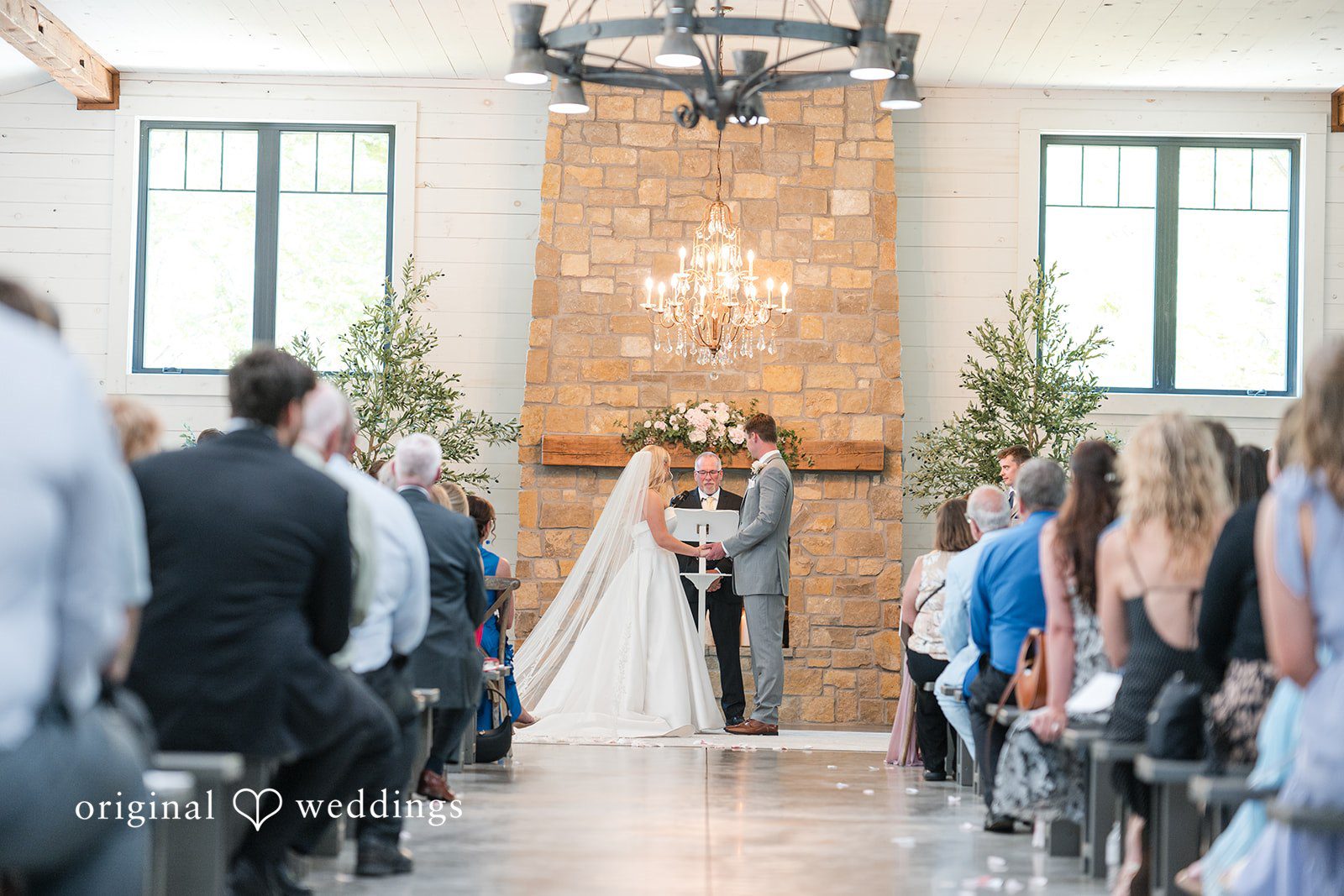Cassandra + Adam Wedding ceremony underway at the front of a chapel filled with guests.