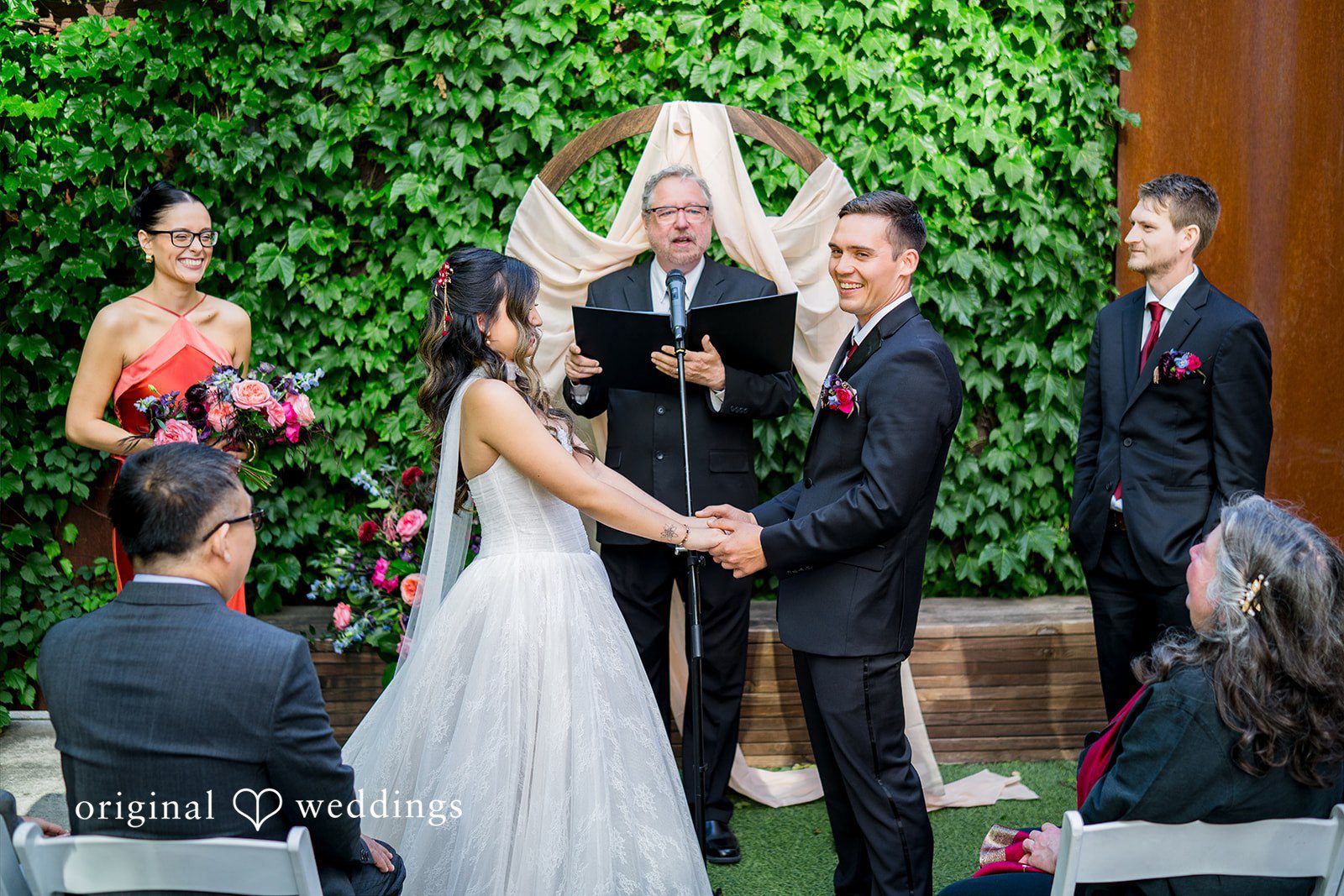 Bride and groom holding hands before the priest  at Lytle House