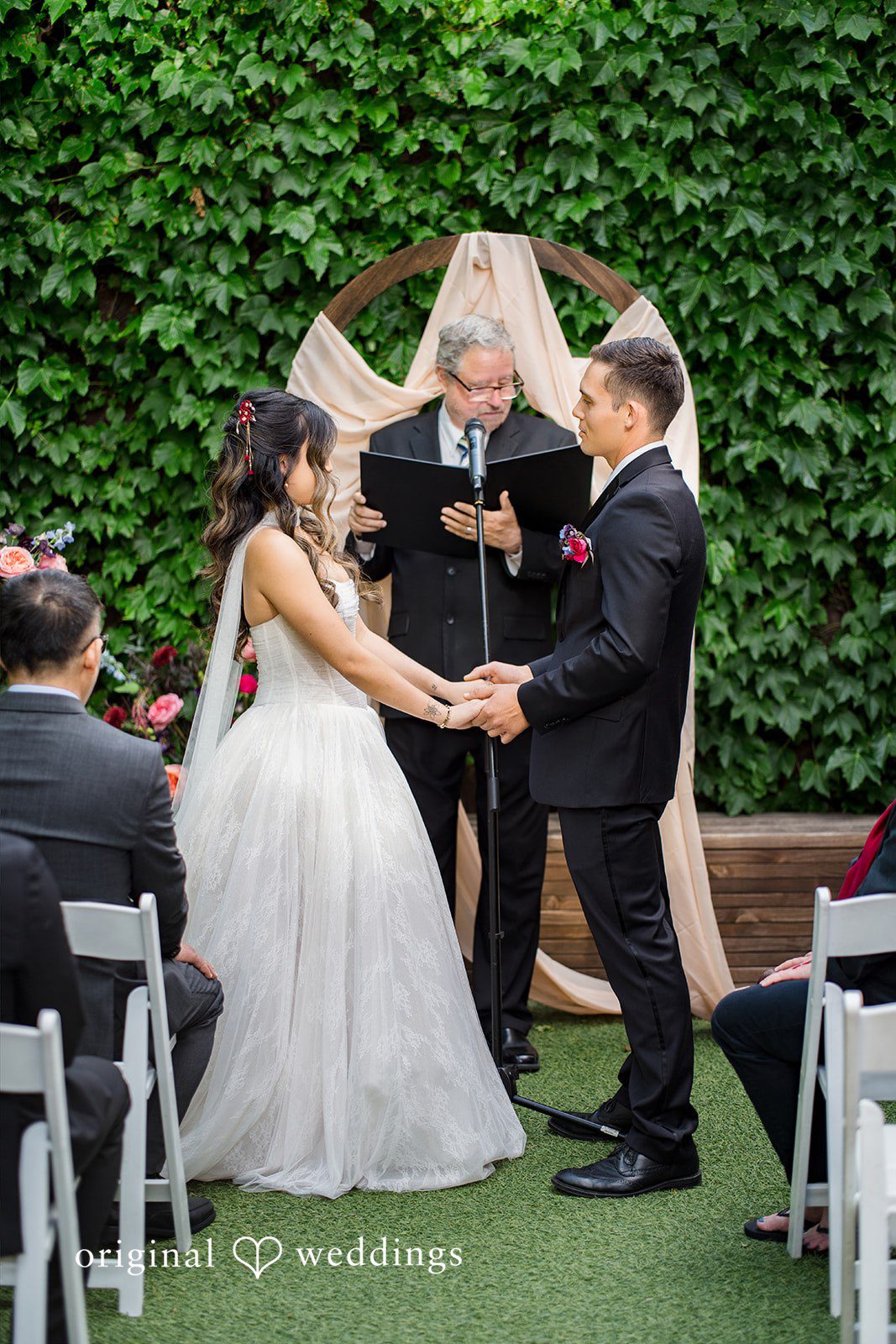Couple sharing eye contact while holding hands during the ceremony at Lytle House