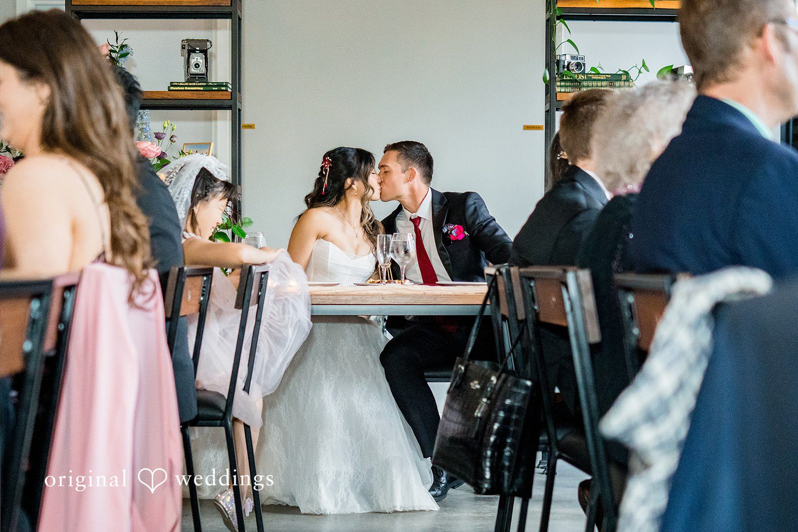 Bride and groom kissing at the reception table at Lytle House