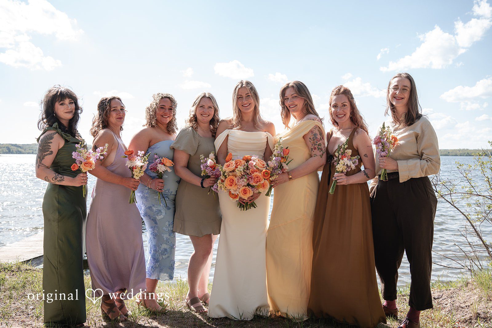Annie + Andrew Group shot of bride with bridesmaids next to the lake at Madden's On Gull Lake