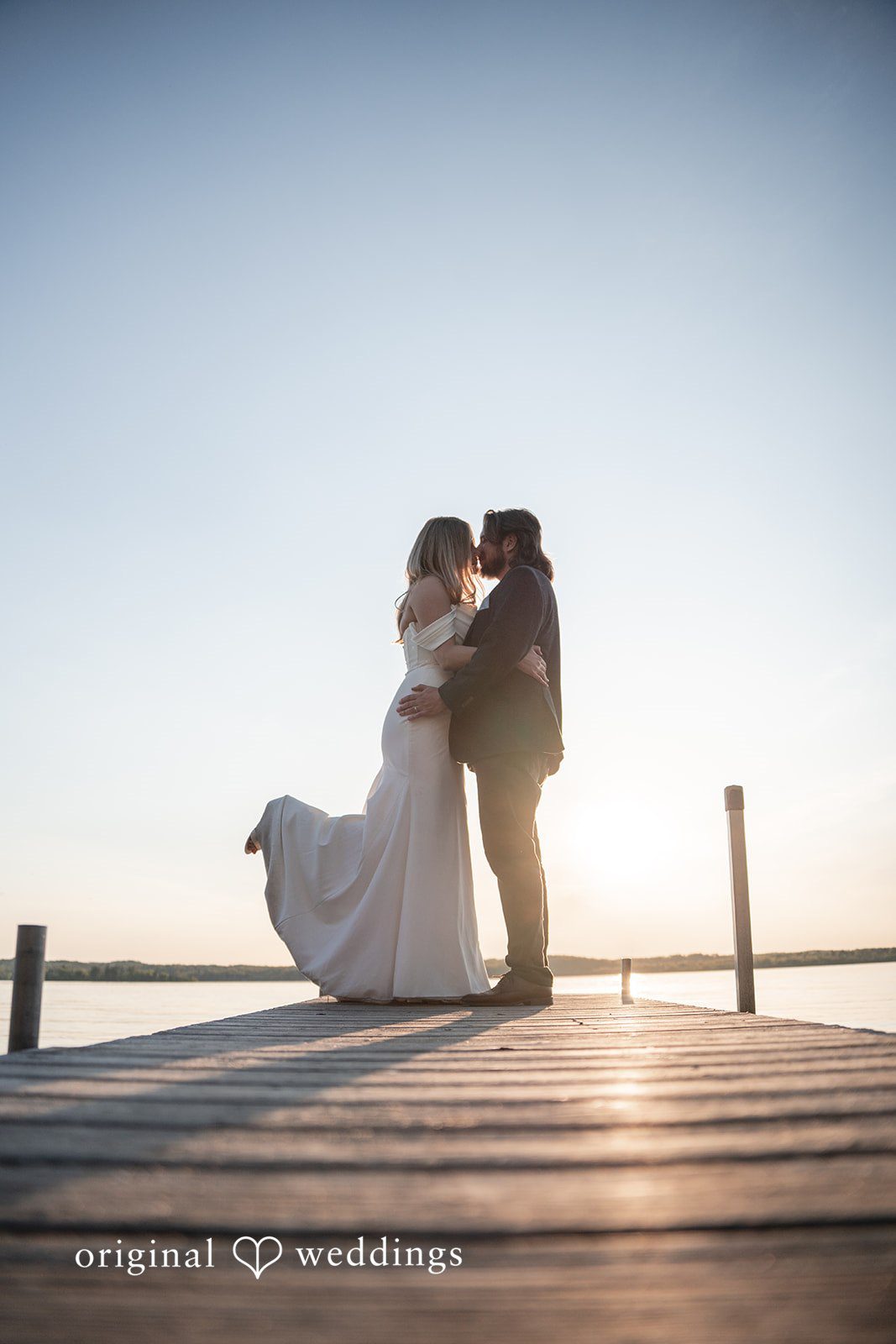 Annie + Andrew Scenic shot of bride and groom at the bridge of lake at Madden's On Gull Lake