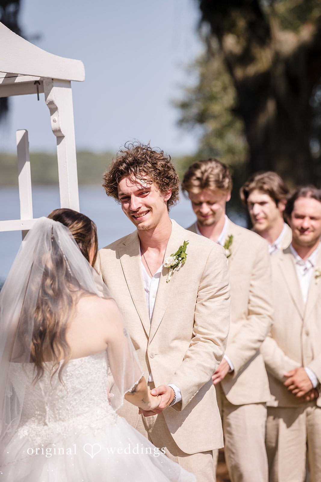 Madison + Aiden Groom smiling as he holds his bride's hands during the ceremony