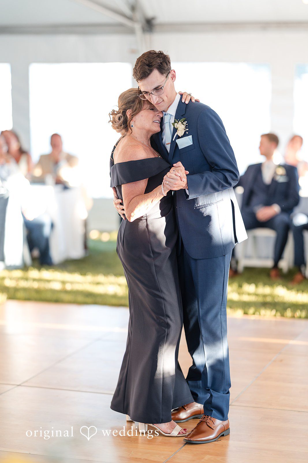 John + Emma Groom dancing with a woman in a dark dress.