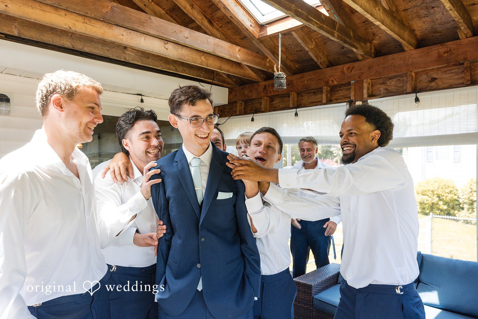 John + Emma Groom celebrating and laughing with his groomsmen before the ceremony.