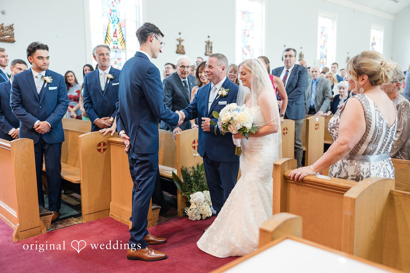 John + Emma Wedding guests watching the ceremony from wooden church pews.