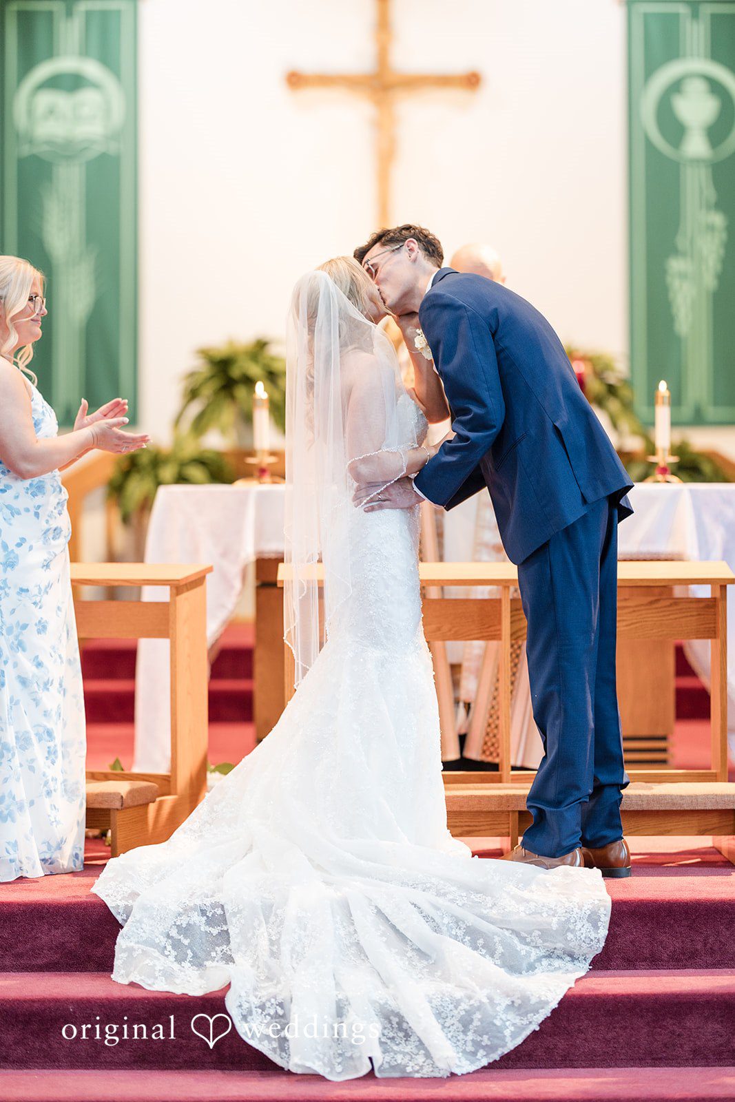 John + Emma Bride and groom sharing a kiss at the altar.