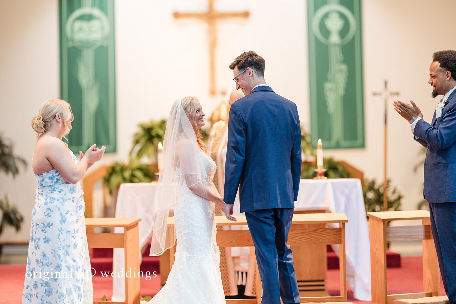 John + Emma Bride and groom facing each other at the altar with attendants.