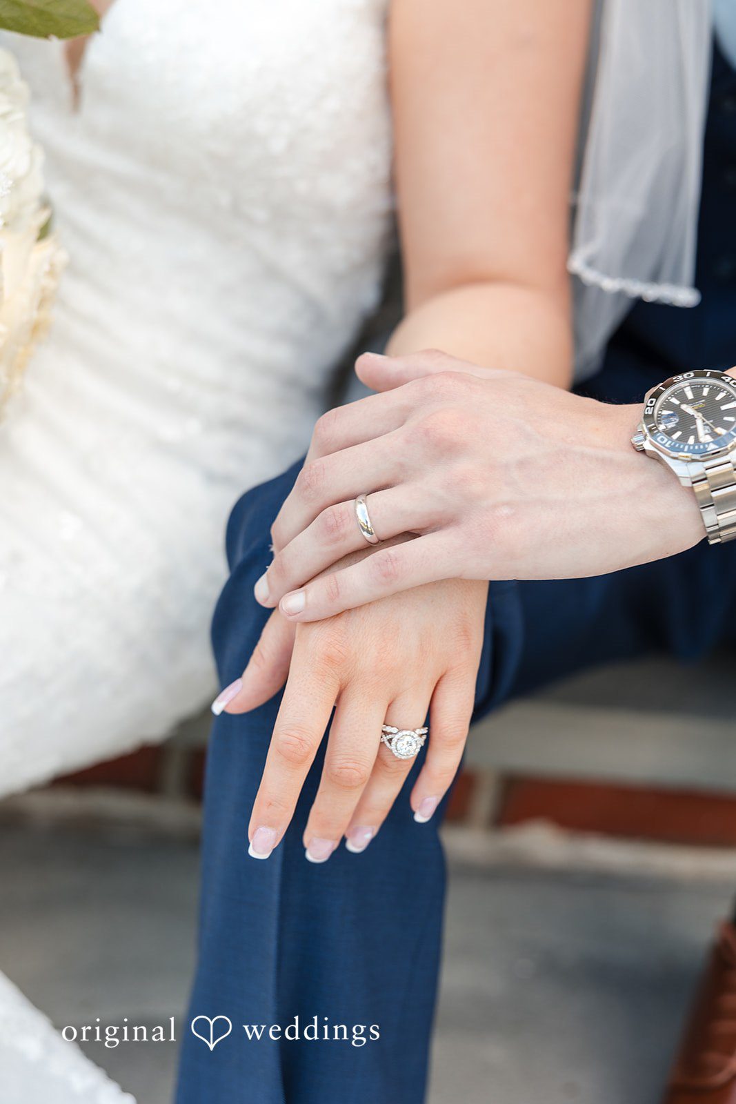 John + Emma Close-up of the couple holding hands to show rings.