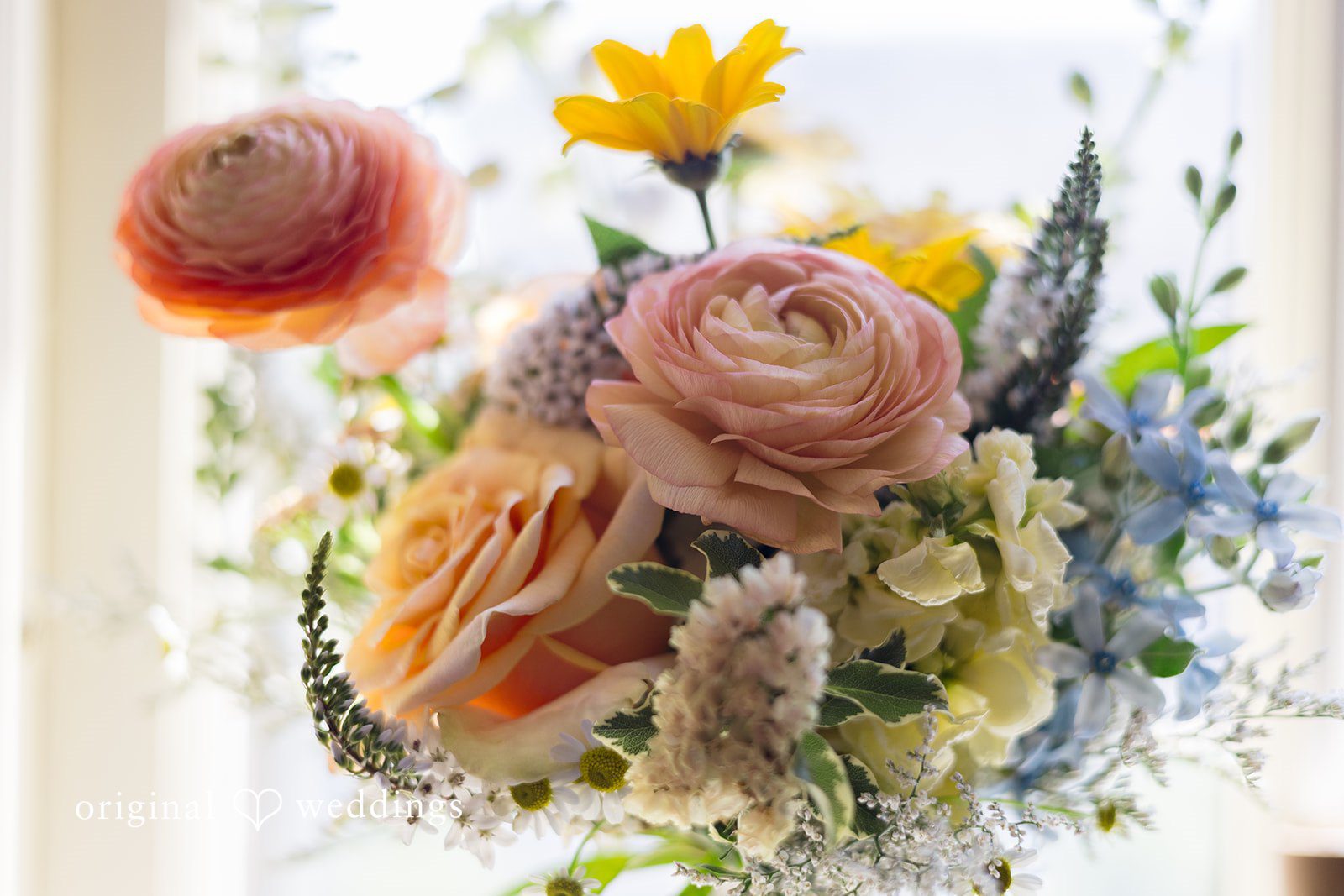 Close-up of a beautiful bridal bouquet featuring pastel roses and seasonal flowers.