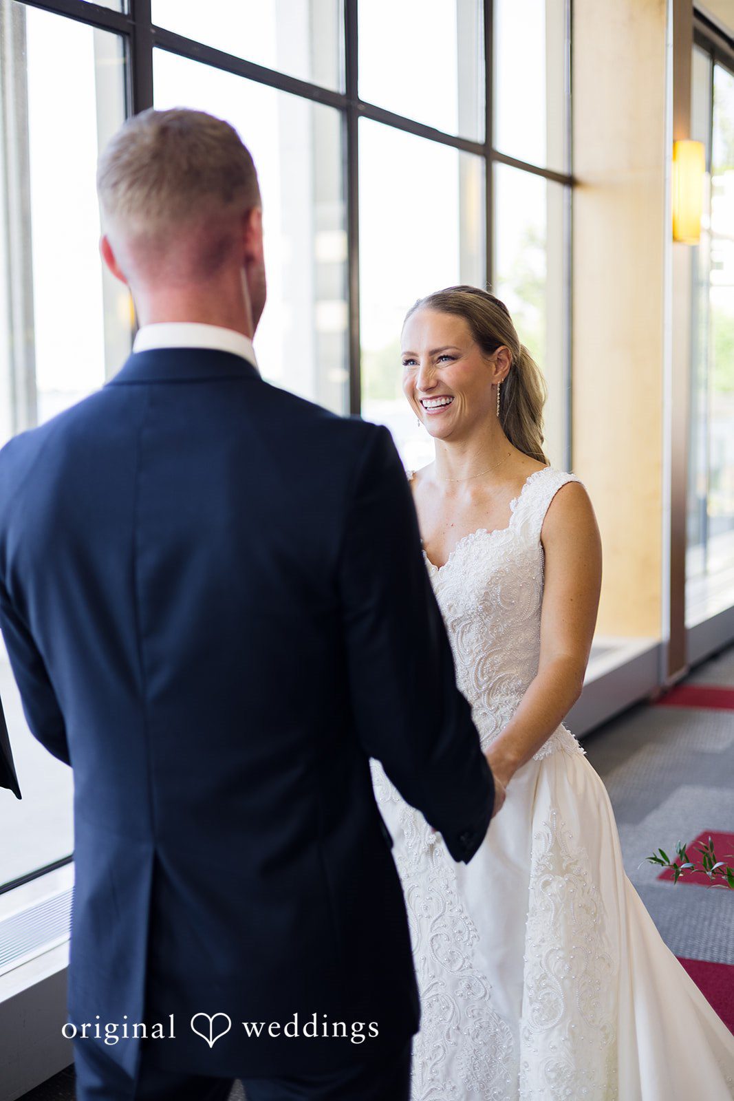 Bride and groom smiling during their wedding ceremony at Memorial Union captured by Madison Wedding Photographers from Original Weddings.