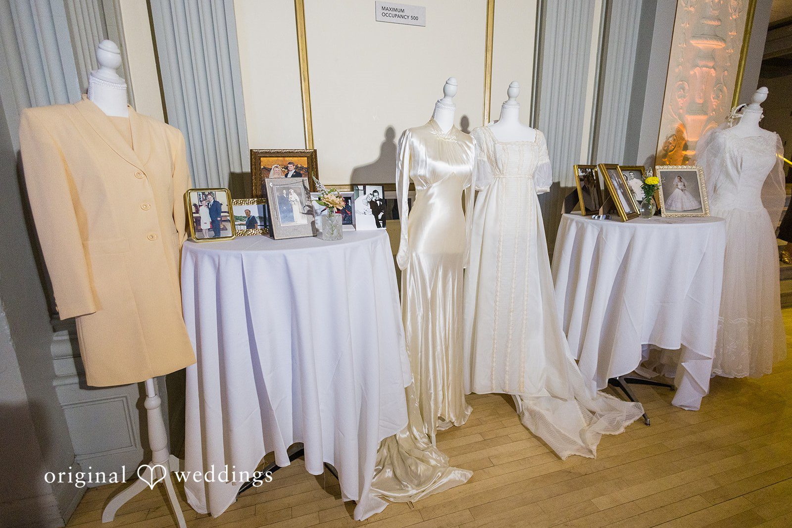Elegant wedding dress display with framed family photographs at Memorial Union.