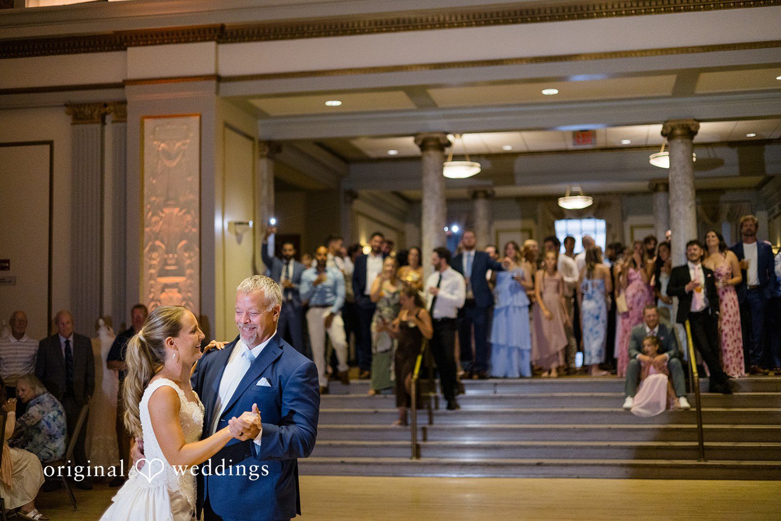 Bride sharing a joyful dance with a loved one at Memorial Union captured by Madison Wedding Photographers from Original Weddings.
