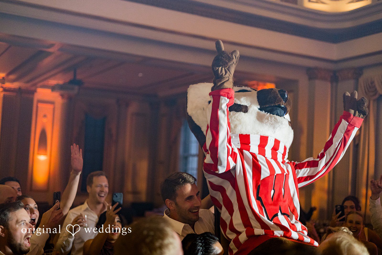Guests cheering as Bucky Badger joins the wedding reception at Memorial Union.