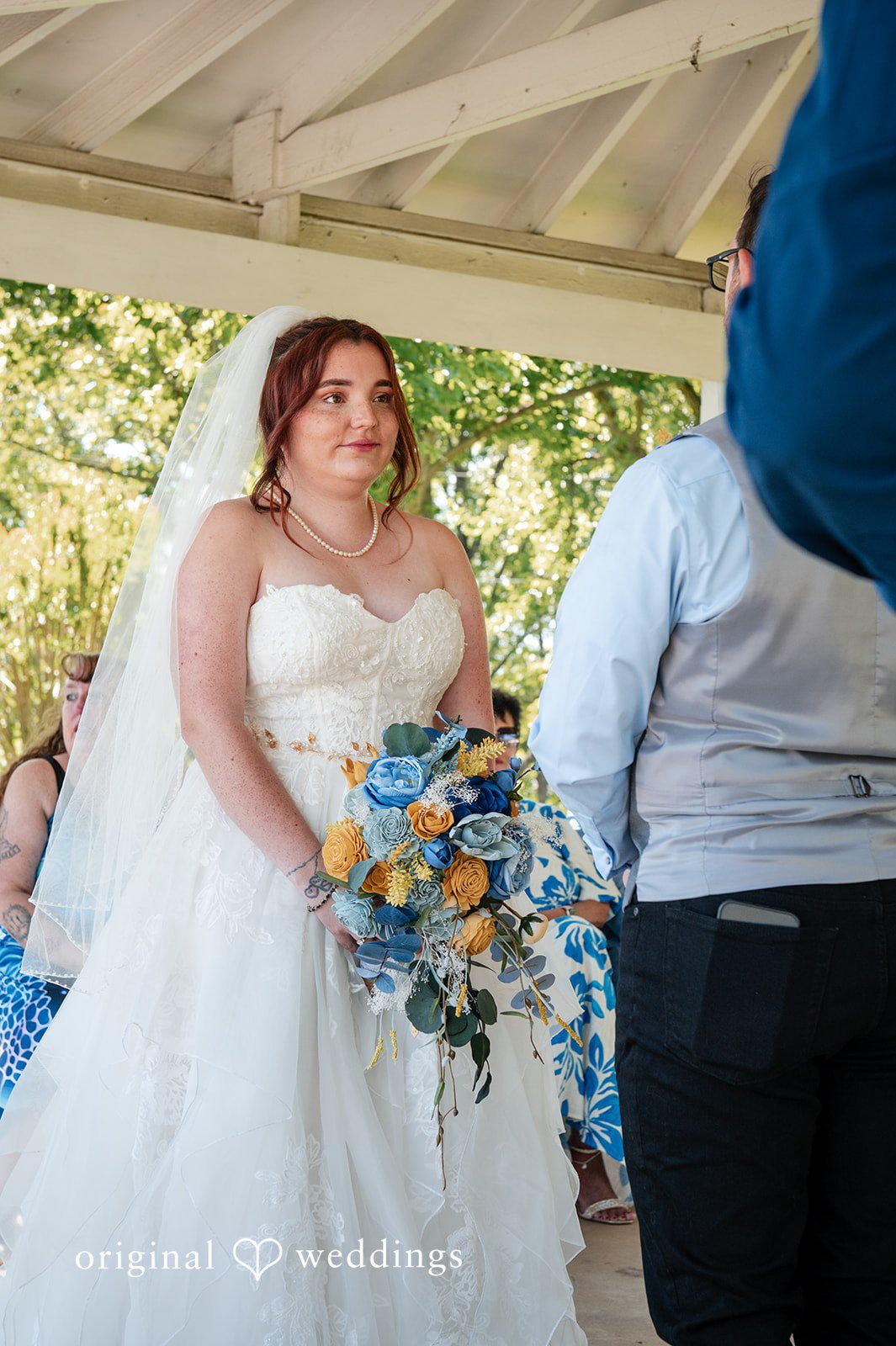Joshua + Angela A bride in a strapless gown smiles while looking at her groom at the altar.