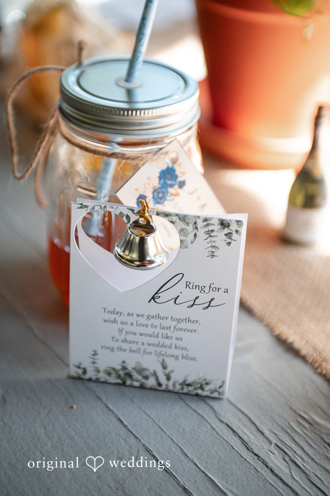 Joshua + Angela A close-up view of a wedding favor display featuring a glass jar and a white card with cursive writing.