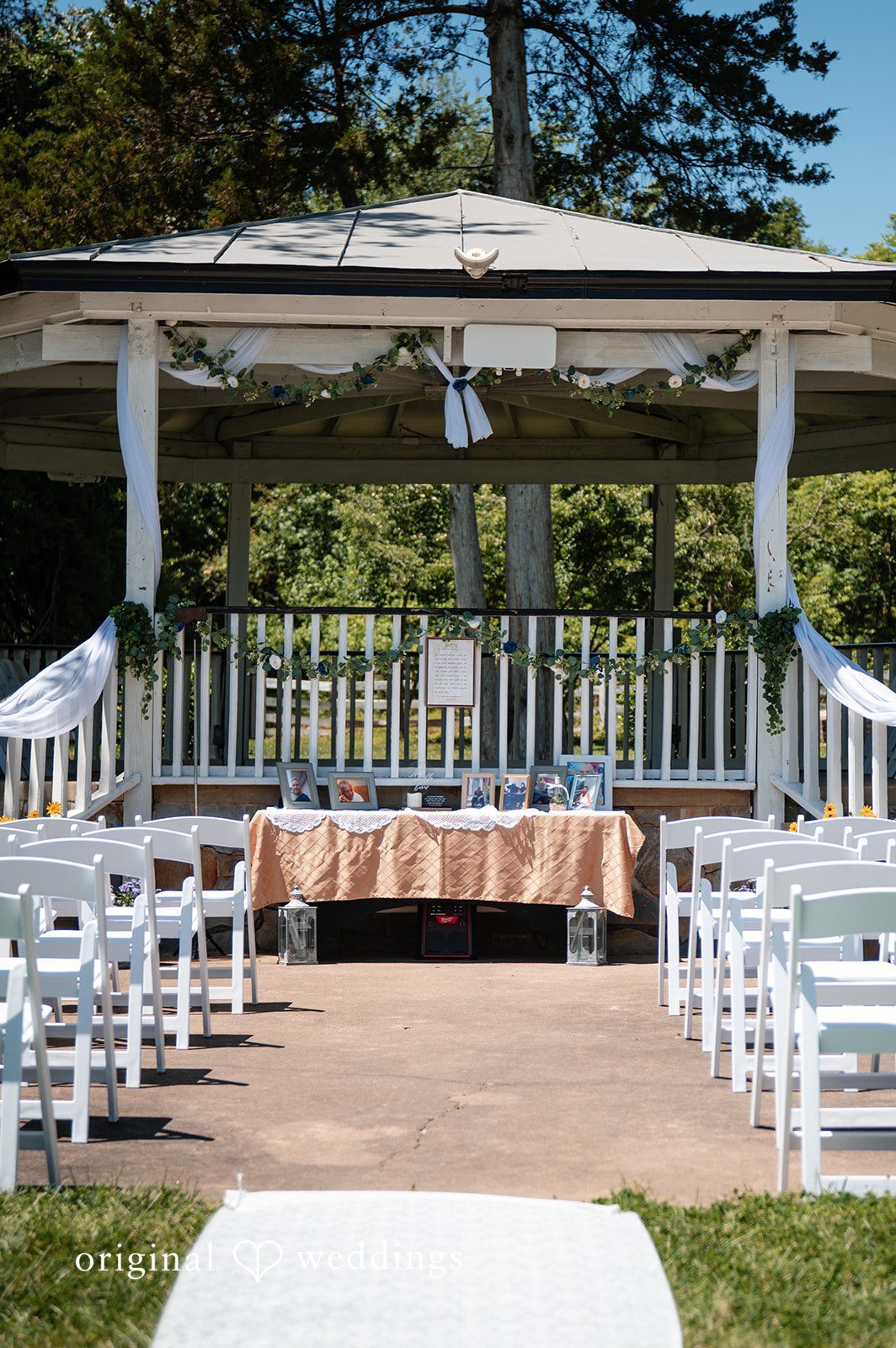 Joshua + Angela A white wedding ceremony pavilion with rows of white chairs facing a central altar table.