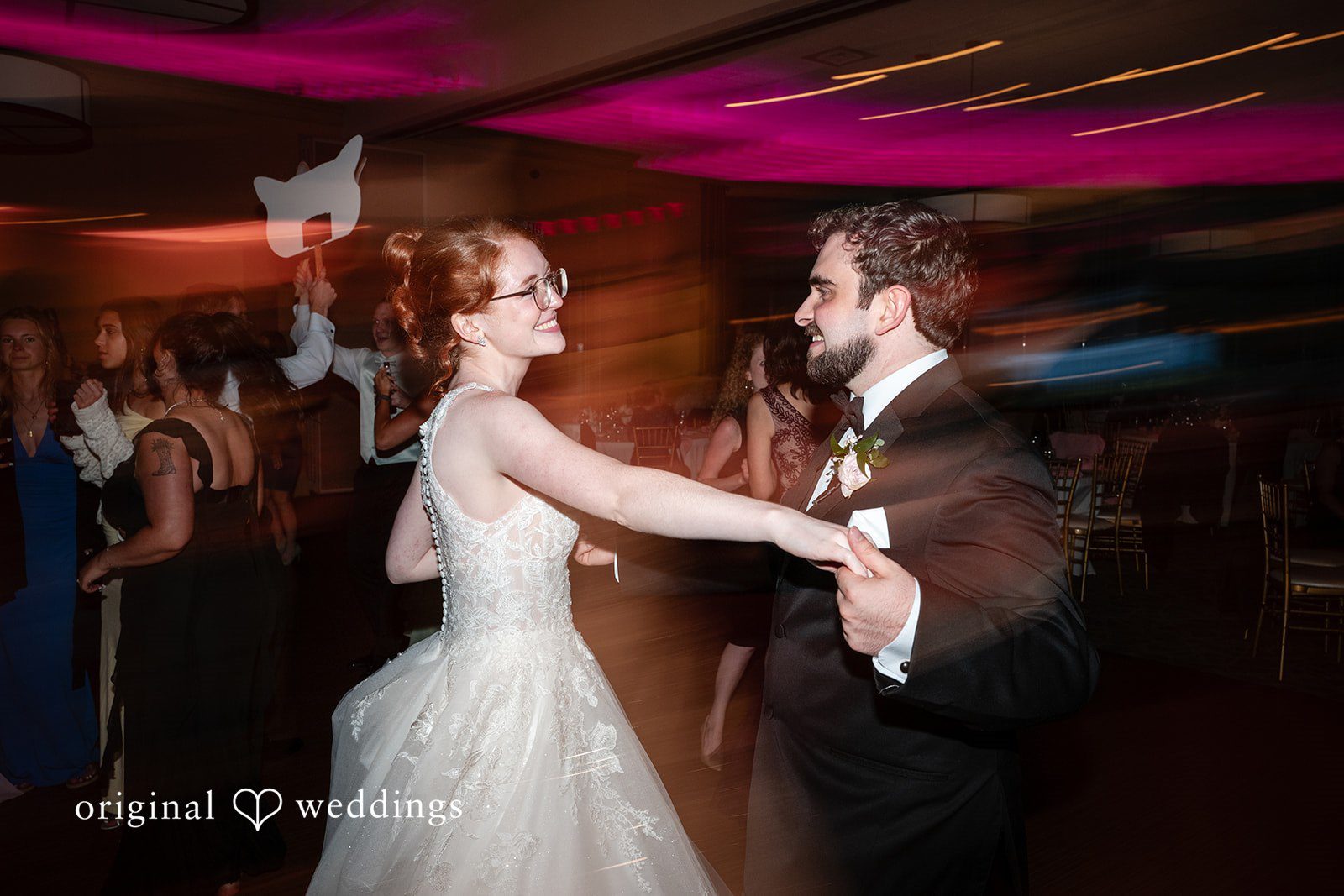 Aislyn + Alex Action shot of the newlyweds dancing energetically under vibrant reception lighting.