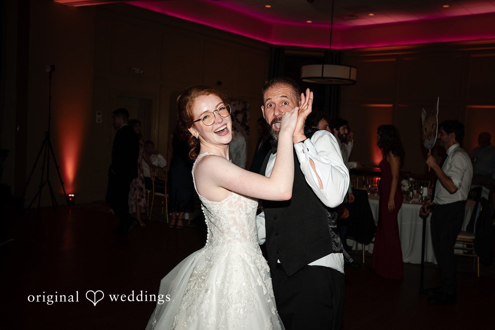 Aislyn + Alex Happy bride and man holding hands while dancing on the dance floor.