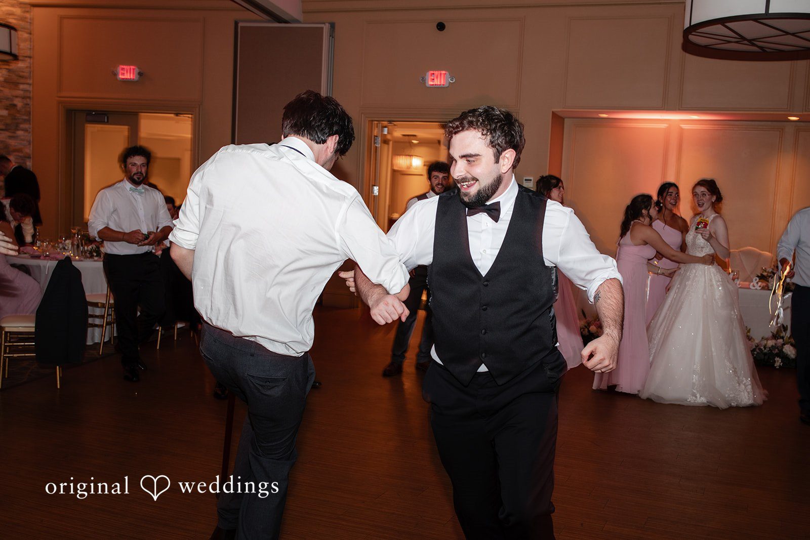 Aislyn + Alex Groom and groomsmen in white shirts and vests dancing together during the party.