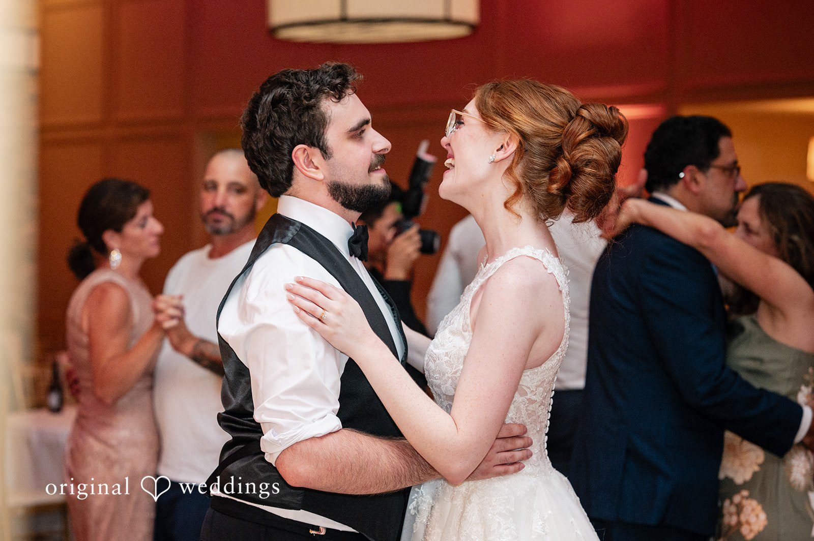 Aislyn + Alex Groom smiling at the bride while dancing among guests at the reception.