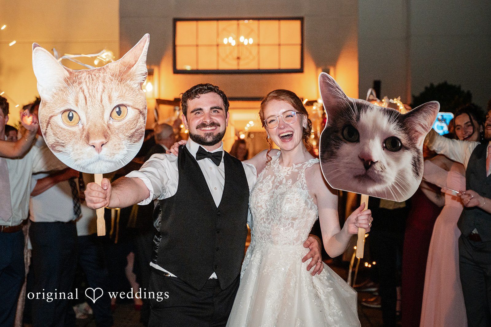 Aislyn + Alex Newlyweds posing playfully on the dance floor while a guest holds a cat cutout.